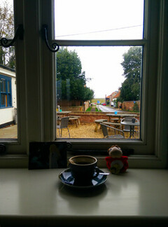 A windowsill looking out to a road going to a creek and marsh.